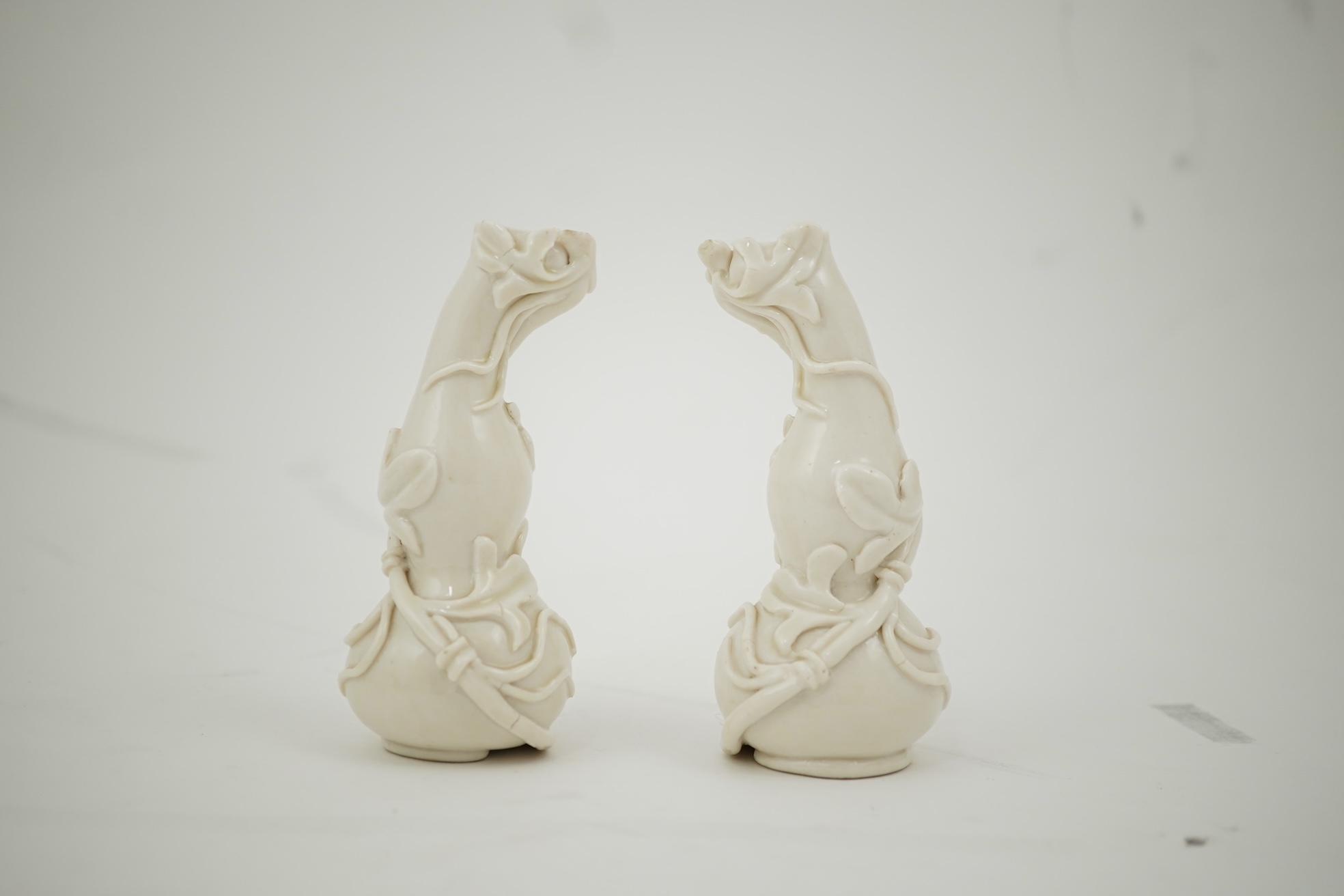 A pair of Chinese blanc-de-chine gourd-shaped vases, Dehua kilns, Qing dynasty